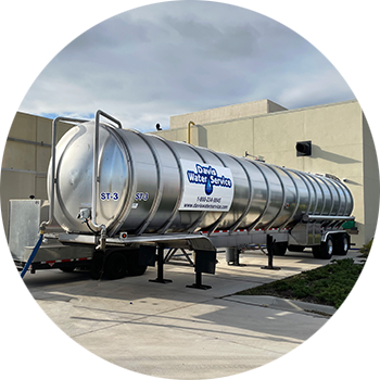 Tanker stationed outside facility, dispensing water.